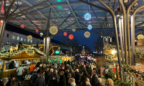 Weihnachtsmarktbesucherinnen und -besucher unter dem Glasdach auf dem Wolfsburger Weihnachtsmarkt